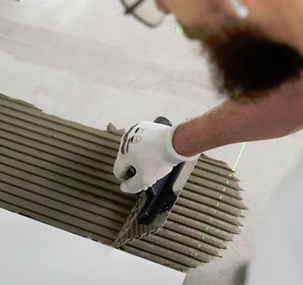 Handwerker beim verteilen von Fließenkleber