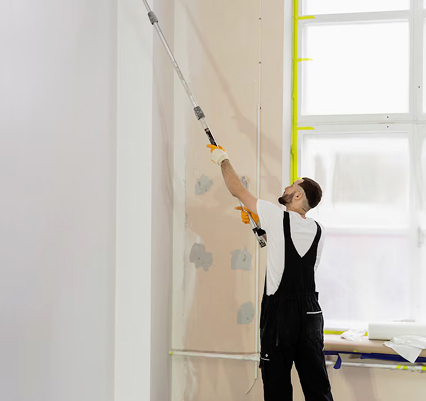 Maler, beim streichen einer weißen Wand mit einer Farbrolle